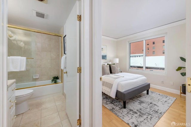 ensuite bathroom featuring toilet, ensuite bath, enclosed tub / shower combo, ornamental molding, and vanity