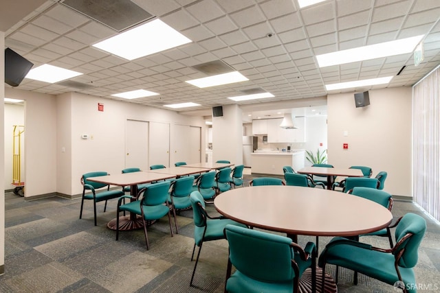 dining space with a drop ceiling and baseboards