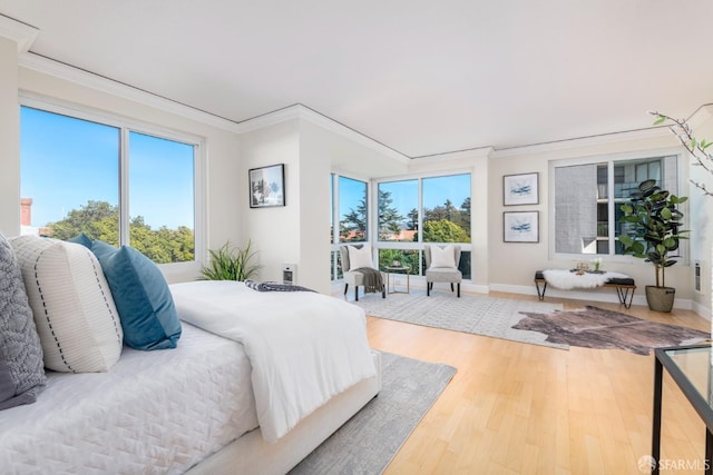 bedroom featuring crown molding, baseboards, and wood finished floors