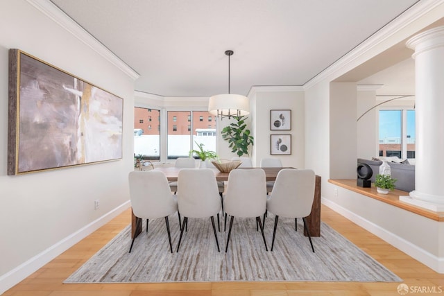 dining room with light wood-style flooring, plenty of natural light, decorative columns, and crown molding