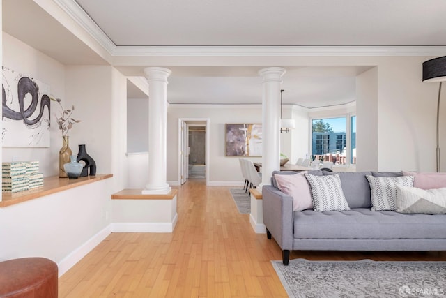 living room featuring decorative columns, ornamental molding, and light wood-style flooring