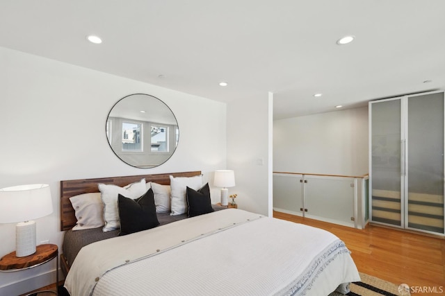 bedroom with wood finished floors and recessed lighting