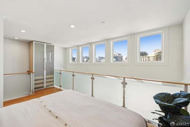 bedroom featuring wood finished floors, recessed lighting, and baseboards