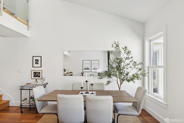 dining space featuring wood finished floors, stairway, and baseboards