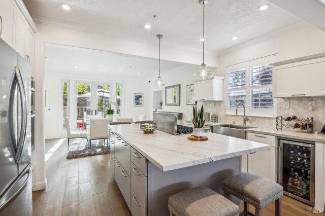 110 Baypoint Dr, San Rafael, CA 94901 - kitchen featuring beverage cooler, a sink, freestanding refrigerator, crown molding, and dark wood-type flooring