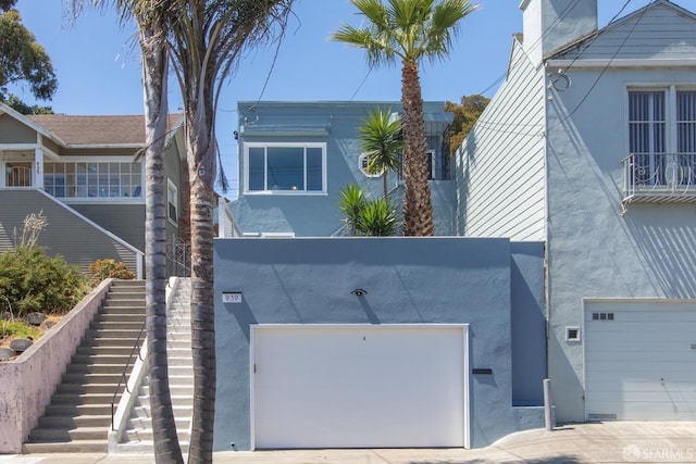 939 Innes Ave, San Francisco, CA 94124 - view of front of property featuring stucco siding, stairway, and an attached garage