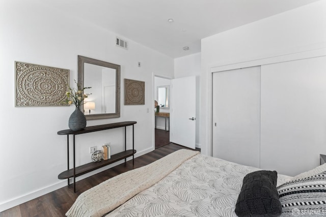 bedroom with visible vents, baseboards, a closet, and wood finished floors