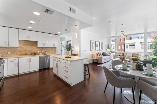 kitchen with tasteful backsplash, visible vents, a breakfast bar, and stainless steel dishwasher