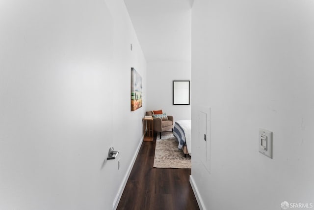 hallway with dark wood-type flooring and baseboards