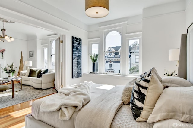 bedroom featuring an inviting chandelier and hardwood / wood-style floors