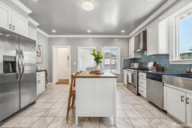 882 56th St, Oakland, CA 94608 - kitchen featuring stainless steel appliances, wall chimney range hood, light marble finish flooring, plenty of natural light, and recessed lighting