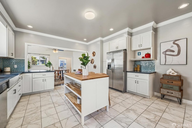 882 56th St, Oakland, CA 94608 - kitchen featuring stainless steel refrigerator with ice dispenser, open shelves, light marble finish floors, recessed lighting, and butcher block countertops