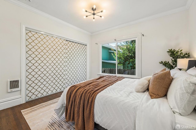 882 56th St, Oakland, CA 94608 - bedroom featuring heating unit, wood finished floors, a chandelier, and crown molding