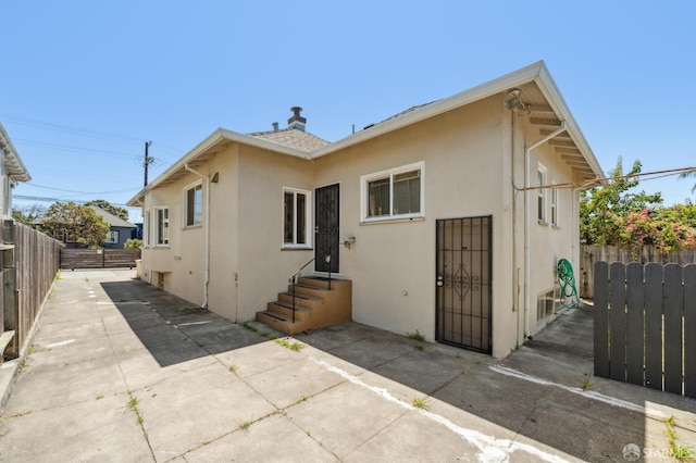 882 56th St, Oakland, CA 94608 - back of house with stucco siding, a fenced backyard, a patio, and entry steps