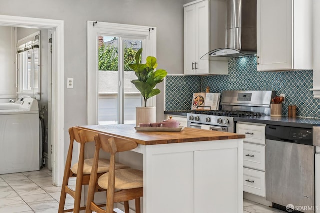 882 56th St, Oakland, CA 94608 - kitchen featuring wall chimney exhaust hood, butcher block counters, stainless steel appliances, and light marble finish floors