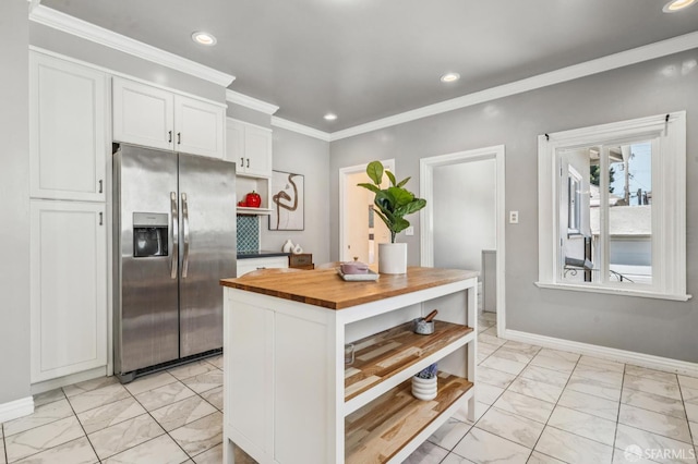 882 56th St, Oakland, CA 94608 - kitchen with stainless steel fridge with ice dispenser, light marble finish floors, wood counters, open shelves, and white cabinets