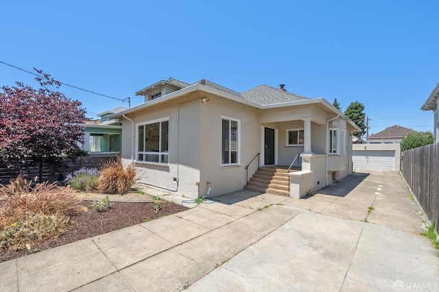 882 56th St, Oakland, CA 94608 - bungalow-style home featuring stucco siding, a garage, and roof with shingles
