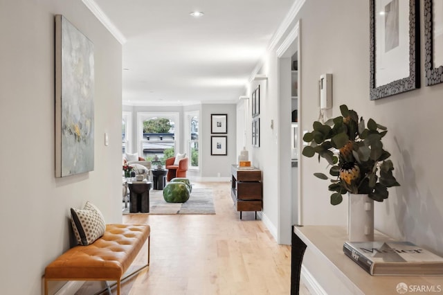 hall with light hardwood / wood-style flooring and ornamental molding