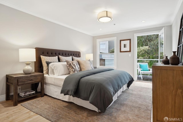 bedroom featuring ornamental molding, access to exterior, multiple windows, and light wood-type flooring