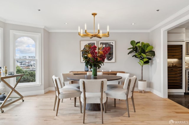 dining area with crown molding, a notable chandelier, and light wood-type flooring