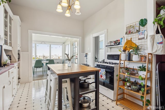 522 Liberty St, San Francisco, CA 94114 - kitchen featuring light floors, butcher block countertops, white cabinetry, and gas range gas stove