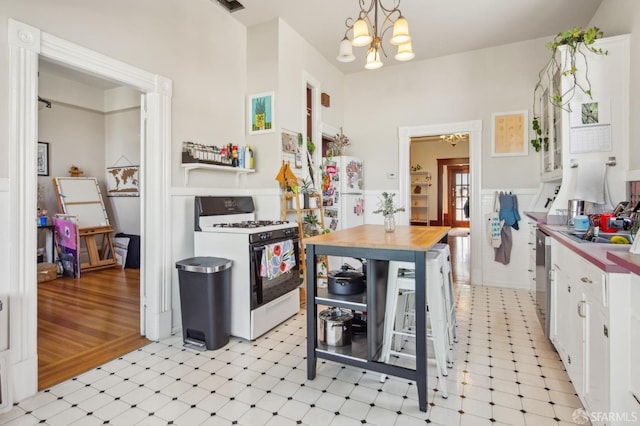 522 Liberty St, San Francisco, CA 94114 - kitchen with light floors, white appliances, a chandelier, white cabinetry, and pendant lighting