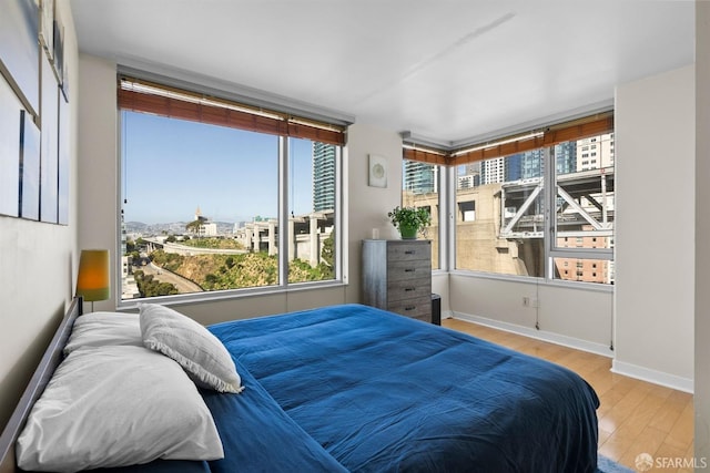 bedroom with light hardwood / wood-style floors and multiple windows