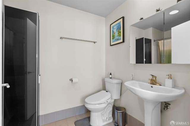 bathroom featuring walk in shower, toilet, and tile patterned floors