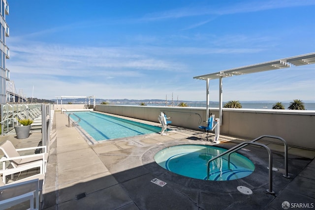 view of swimming pool featuring a patio and a water view