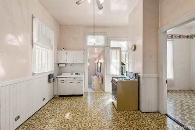 1075 Noe St, San Francisco, CA 94114 - kitchen featuring wainscoting, gas range, ceiling fan, light countertops, and white cabinets