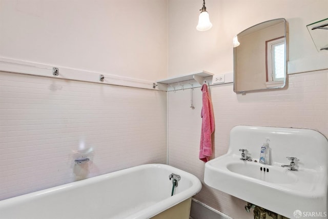 1075 Noe St, San Francisco, CA 94114 - bathroom featuring tile walls, a soaking tub, wainscoting, and a sink