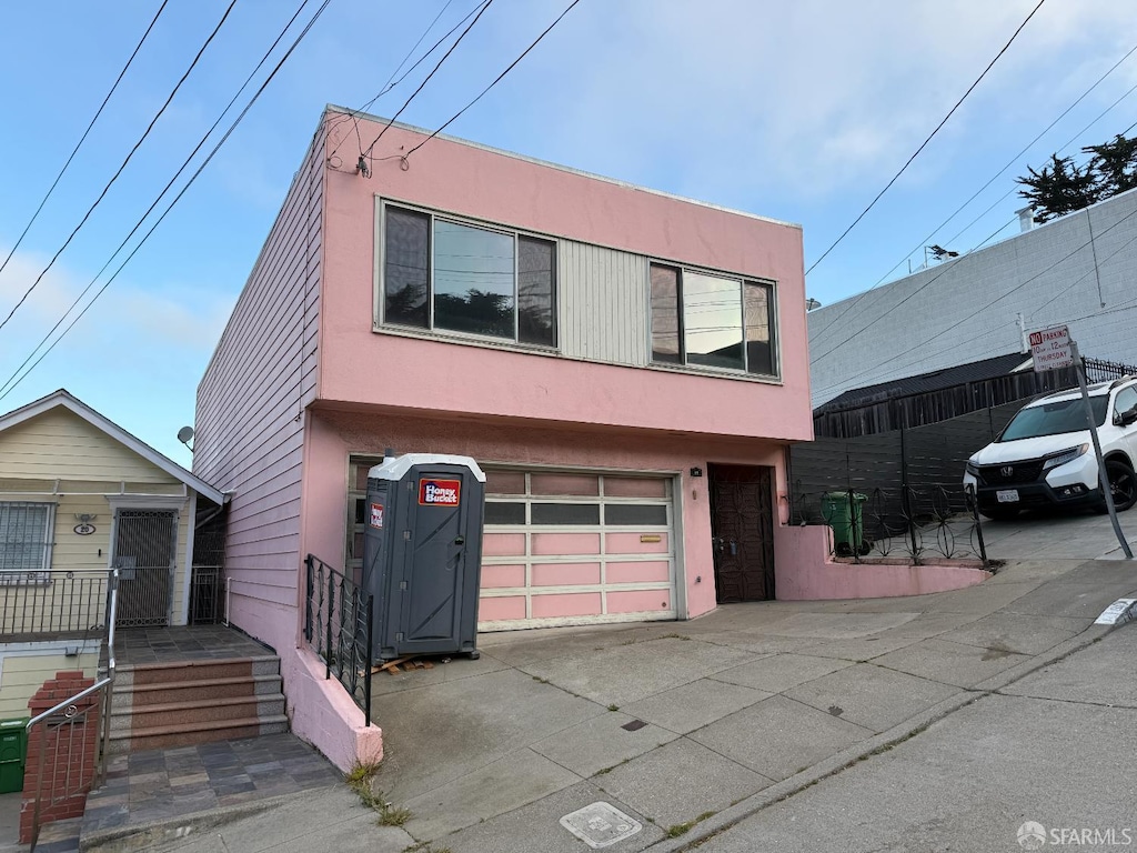 18 Prague St, San Francisco, CA 94112 - view of front of home with driveway, stucco siding, and an attached garage