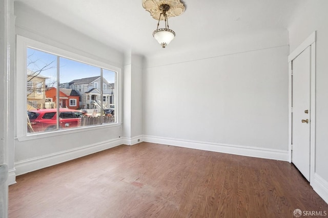 unfurnished dining area featuring wood finished floors and baseboards