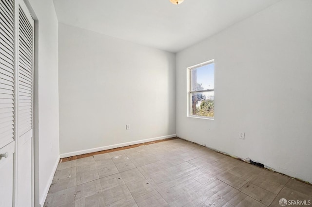 unfurnished bedroom with a closet and baseboards