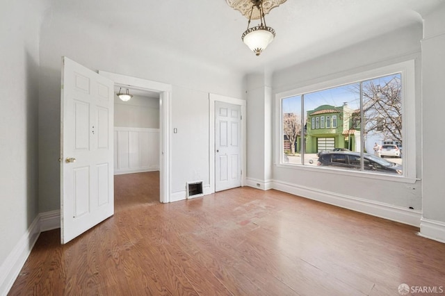 unfurnished bedroom featuring visible vents, baseboards, and wood finished floors