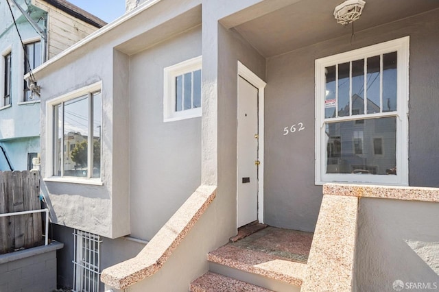 entrance to property featuring stucco siding