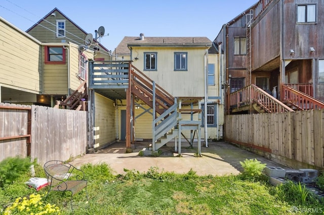 rear view of property featuring stairway, a deck, a patio, and a fenced backyard