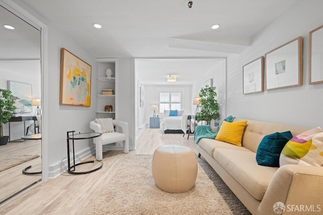 living area featuring built in shelves, wood finished floors, and recessed lighting