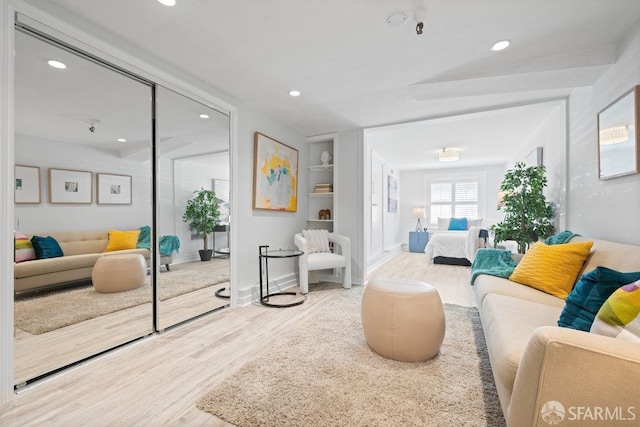 living room with baseboards, wood finished floors, built in features, and recessed lighting