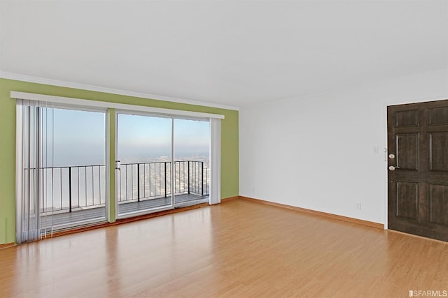 empty room with crown molding and hardwood / wood-style flooring