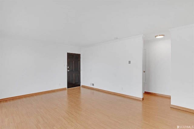 unfurnished room featuring ornamental molding and light wood-type flooring