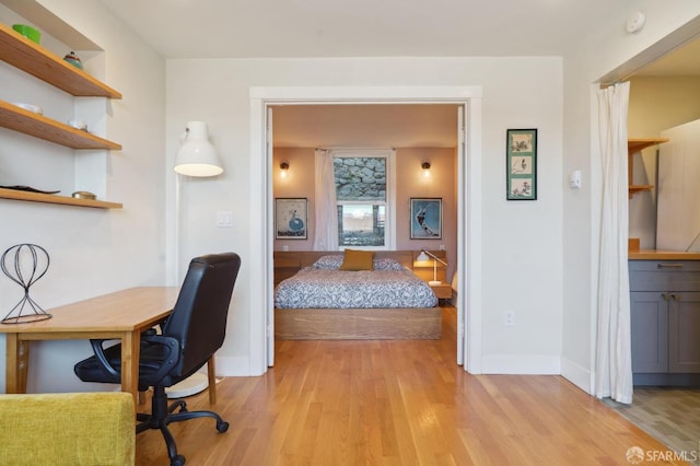 bedroom with light wood-style flooring and baseboards