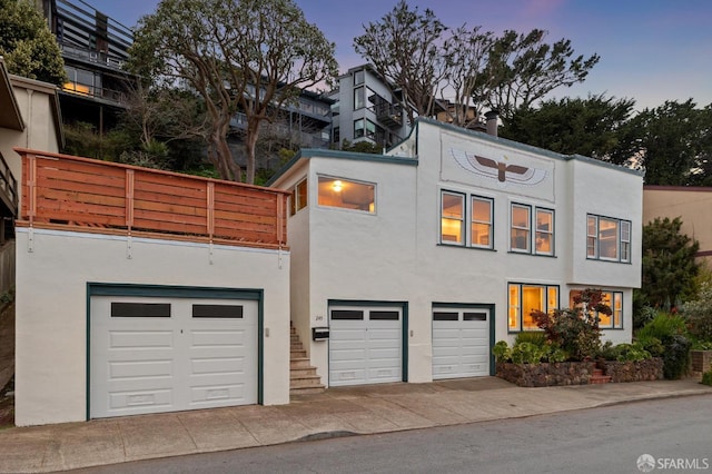 view of front of property featuring a garage, driveway, and stucco siding