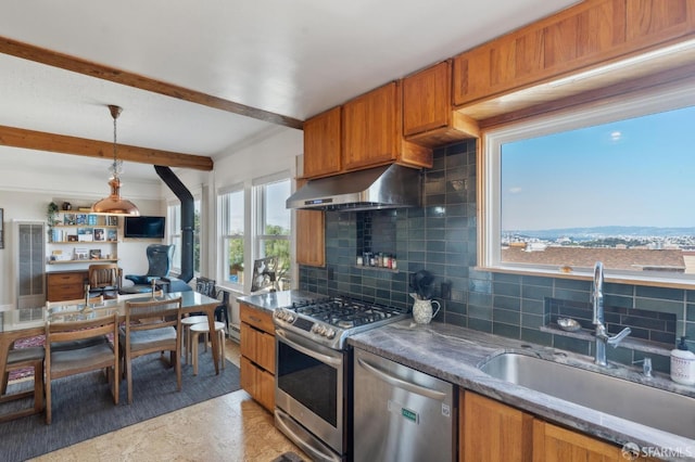 kitchen featuring brown cabinets, under cabinet range hood, a sink, appliances with stainless steel finishes, and decorative backsplash