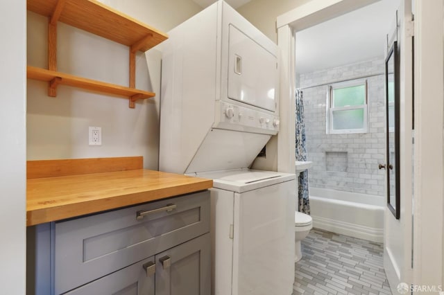 full bathroom featuring stacked washer / dryer, toilet, and shower / bath combo