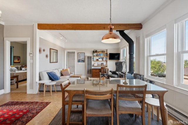 dining area with beam ceiling, rail lighting, a baseboard radiator, and ornamental molding