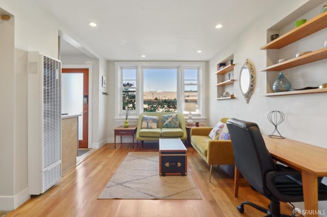 office area featuring recessed lighting, baseboards, a heating unit, and light wood finished floors