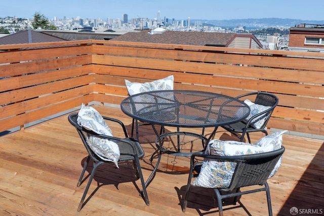 wooden deck featuring outdoor dining space and a view of city