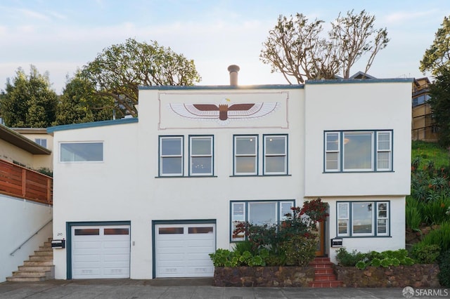 view of front of house featuring stairway, stucco siding, and an attached garage