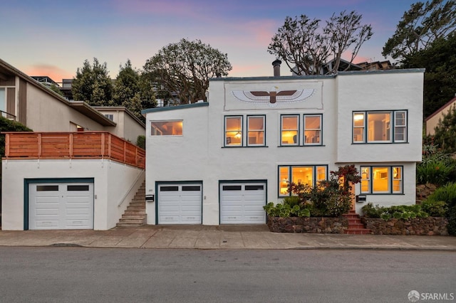 view of front of house featuring stairway, stucco siding, and a garage